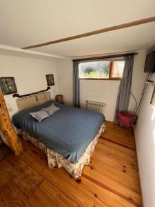 1 dormitorio con 1 cama en una habitación con ventana en Pul Mari en San Carlos de Bariloche