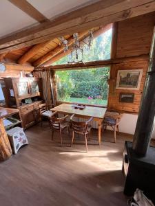 comedor con mesa, sillas y ventana en Pul Mari en San Carlos de Bariloche