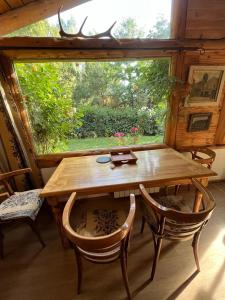 een houten tafel en stoelen in een kamer met een raam bij Pul Mari in Bariloche