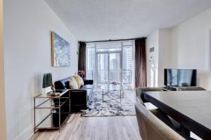 a living room with a couch and a tv at Grand Royal condos SQ One Mississauga in Mississauga