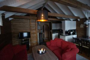 a living room with two red chairs and a table at Strandbu in Viksdalen