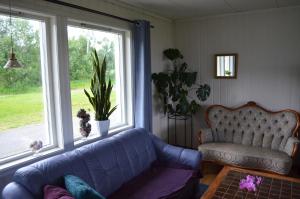 uma sala de estar com um sofá e duas janelas em Apartament Sandstrand 