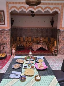 a table with plates of food on it in a room at Riad Kanata in Marrakesh