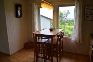 a table and chairs in a room with a window at Apartament Sandstrand in Tovik