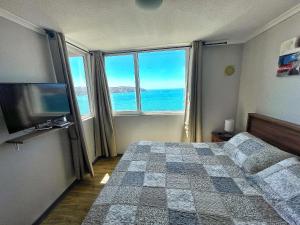 um quarto com uma cama e uma grande janela com o oceano em DEPARTAMENTO EN PLAYA LA HERRADURA (CONDOMINIO BAHÍA HORIZONTE) +569 95468707 em Coquimbo
