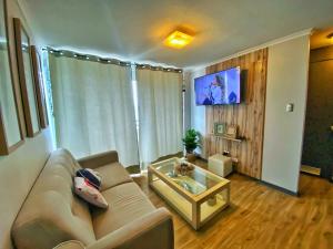 uma sala de estar com um sofá e uma mesa de vidro em DEPARTAMENTO EN PLAYA LA HERRADURA (CONDOMINIO BAHÍA HORIZONTE) +569 95468707 em Coquimbo