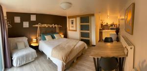 1 dormitorio con 1 cama, 1 mesa y 1 silla en Les Saugeys, en Mâcon