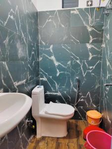 een badkamer met een wit toilet en een wastafel bij Capt. Mount Stays in Rishīkesh