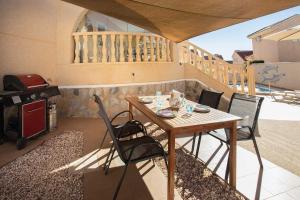 una mesa y sillas en un patio con parrilla en Ch Villa Rio Tajo Rojales, en Rojales