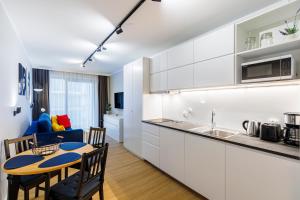 a kitchen and living room with a table and chairs at Balticus Apartamenty Standard Promenada Gwiazd 14 in Międzyzdroje