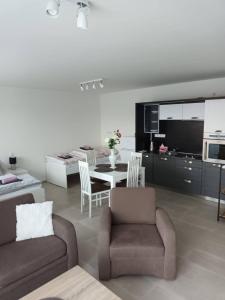 a living room with a couch and a table and a kitchen at Apartmán Mignon in Prachatice