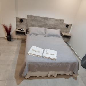 Una cama con dos toallas en una habitación en AZ Suites Resistencia en Resistencia