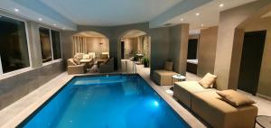 a large swimming pool in a living room with furniture at Boutique Hotel Acacia in Lovran