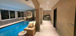 a swimming pool in a house with a couch and a table at Boutique Hotel Acacia in Lovran