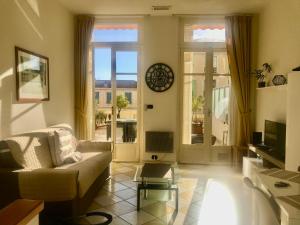 a living room with a couch and a table at Appartement terrasse dans palace Belle Epoque in Menton