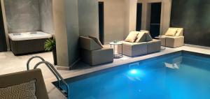 a hotel lobby with a swimming pool with chairs and a tub at Boutique Hotel Acacia in Lovran