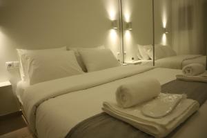 a large white bed with towels and a mirror at Aelia Apartment 2 Ioannina in Ioannina