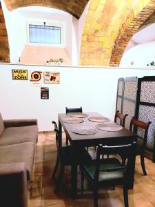 a dining room with a table and a couch at Trastevere in Music in Rome