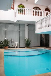 a large swimming pool with a white chair next to a building at Hotel Zaraya in Cúcuta