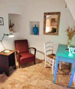 a living room with a table and a chair at Il Trullo del Nonno a Cisternino in Cisternino