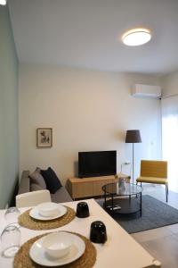 Aelia Apartment 2 Ioannina في يوانينا: غرفة معيشة مع أريكة وطاولة