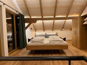 - une chambre avec un lit dans une pièce dotée de plafonds en bois dans l'établissement Mächlerhof, 