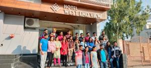 a group of people posing for a picture in front of a hotel restroom at Hotel West End View in Zirakpur