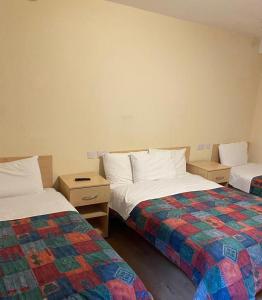 um quarto com duas camas e duas mesas de cabeceira em Seven Dials Hotel em Londres