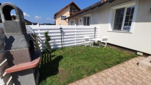 a backyard with a white fence and a table and chairs at Family Residence in Baia Mare