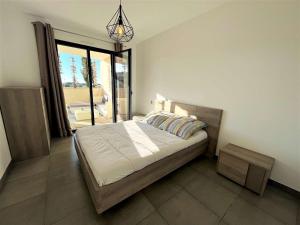 1 dormitorio con cama y ventana grande en Appartement Porticcio, 2 pièces, 4 personnes - FR-1-61-600, en Grosseto-Prugna