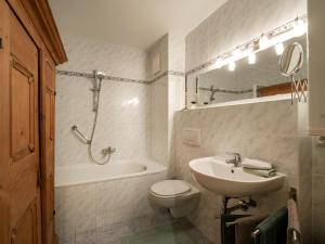 a bathroom with a sink and a toilet and a bath tub at Appartement Gernot in Kirchberg in Tirol