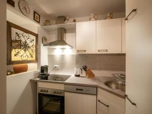 uma cozinha com armários brancos e um lavatório em Appartement Gernot em Kirchberg in Tirol