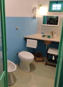 a bathroom with a white toilet and a sink at Il Trullo del Nonno a Cisternino in Cisternino