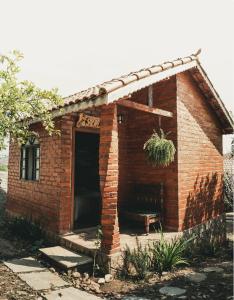 ein kleines Backsteinhaus mit einem Bett darin in der Unterkunft Chalés Vida Verde in Bom Jardim de Minas