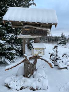 un mangiauccelli nella neve con una casetta per uccelli di Käänu puhkemaja a Rakvere