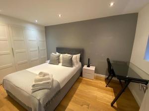 a bedroom with a bed and a desk in it at A beautiful and cozy home in the heart of london in London