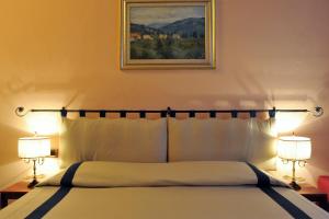 a bedroom with a bed with two lamps and a painting at Residenza Cantagalli in Florence