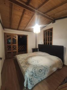 1 dormitorio con 1 cama en una habitación con suelo de madera en Espectacular Casa-Bonobo house al lado del rio en Acacías