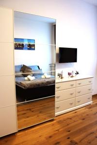 a mirror in a bedroom with a bed and a television at Goldberger Apartment 1020 in Vienna