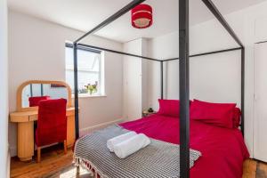 1 dormitorio con cama roja y silla roja en Roof garden house, en Brighton & Hove