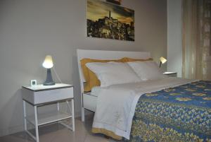 een slaapkamer met een bed en een nachtkastje met een lamp bij Dimora Lucrezia in Matera