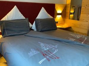 a bed with two pillows on top of it at Luxury Chalet Orchidea -SPA Privata in Canazei