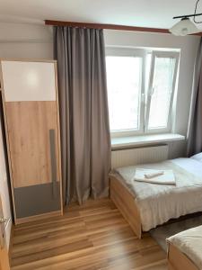 1 dormitorio con 2 camas y ventana en Apartament Praski 5 minut od metra i starego miasta spacerem do zoo i Konesera en Varsovia