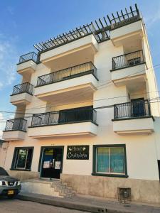 un edificio alto y blanco con balcones. en Hotel Cangrejalito, en Santa Marta