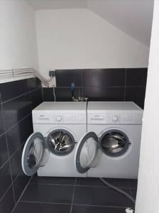 uma máquina de lavar e secar roupa numa pequena casa de banho em Comfy Cozy Iksia em Ixia