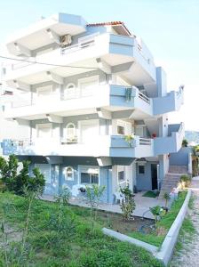 a large white building with blue balconies at Comfy Cozy Iksia in Ixia