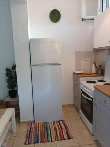 a white kitchen with a refrigerator and a stove at Comfy Cozy Iksia in Ixia