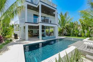 a villa with a swimming pool and a house at All Decked Out in Bailey Hall