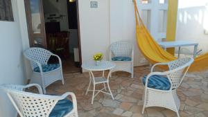 un patio con sillas, una mesa y una hamaca en Paraiso de Maracajaú 1, en Maracajaú