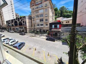a city street with cars parked in a parking lot at Petrópolis. Centro in Petrópolis